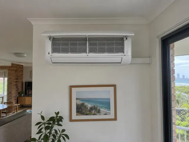 Wall-mounted split system with open front panel and clean filters on a living room wall in Coolangatta