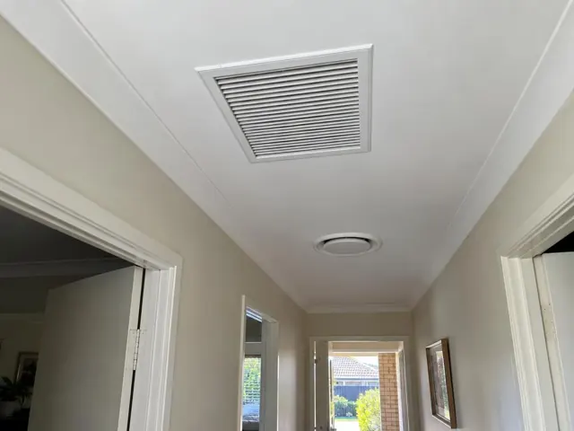 Ceiling return-air grille in a hallway with white trim and beige walls in Tugun